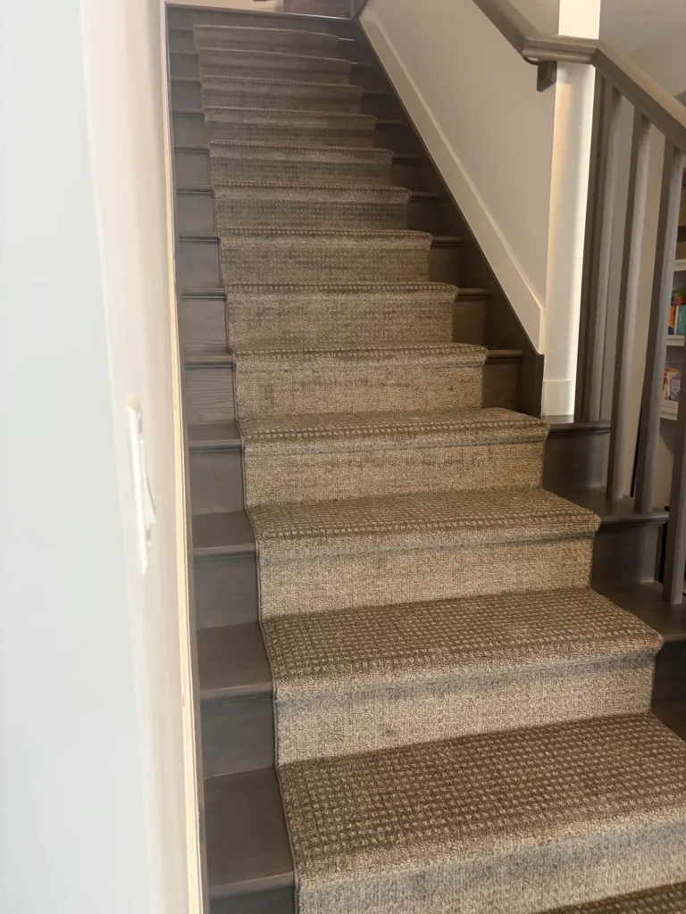 Patterned carpet runner on dark stained hardwood stairs